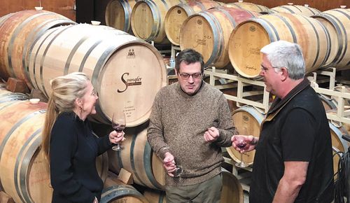 Owner and winemaker Pat Spangler (center), surrounded by barrels, sampling wine with customers. ## Photo provided by Spangler Vineyards