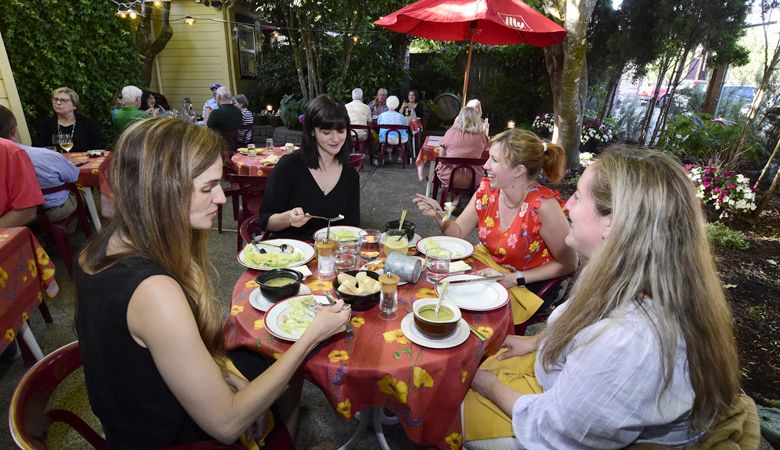 Friends gather for a feast at Bistro Maison in McMinnville. The garden patio is a favorite among tourists and locals. ##Photo by Marcus Larson