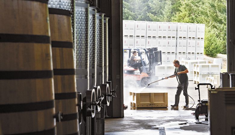 Workers at Penner-Ash Wine Cellars clean picking totes at the Newberg winery, which is now part of Jackson Family Wines. ##Photo by Andrea Johnson