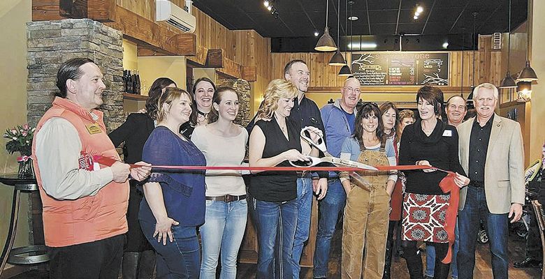Jill House cuts the ribbon at the grand opening of Stave & Stone’s tasting room in Hood River. Family and friends joined in on the celebration. ##Photo provided