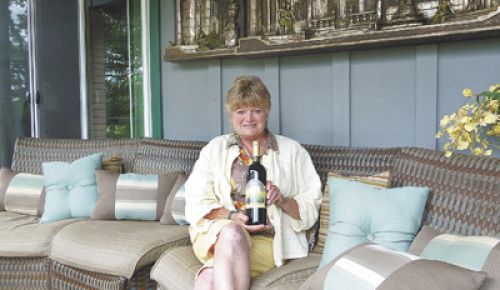Vicki Nickerson holds a bottle of Aurora Vines 2004 Merlot on her tasting deck in Talent.