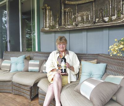 Vicki Nickerson holds a bottle of Aurora Vines 2004 Merlot on her tasting deck in Talent.