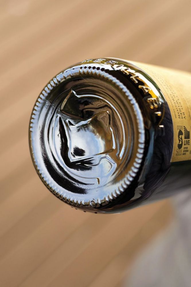 Revino refillable bottles have either the outline of Oregon circled by arrows or solely the circle of arrows in the punt.  ## Photo by Rachel Thompson