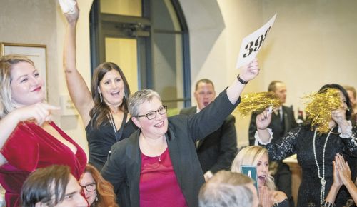 Live bidding on Saturday gets this table excited and in the auction mood. ##Photo by Andrea Johnson