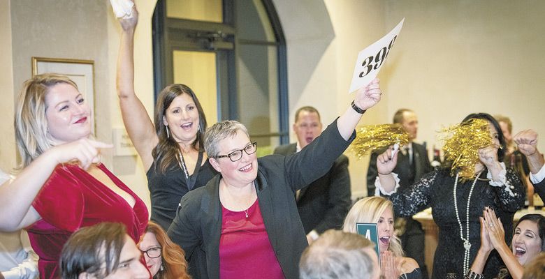 Live bidding on Saturday gets this table excited and in the auction mood. ##Photo by Andrea Johnson