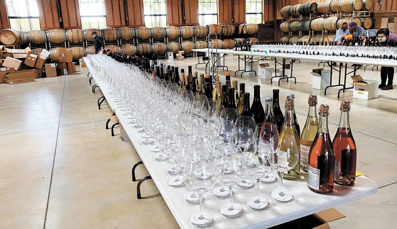 Marked glasses and wines line tables behind the scenes at the 2021 McMinnville Wine & Food Classic Wine Competition. ##Photo provided