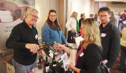 Michael Donovan, of RoxyAnn Winery in Medford, pours samples for eager tasters at the Southern Oregon Wineries Association trade tasting.  Photo by John Darling.