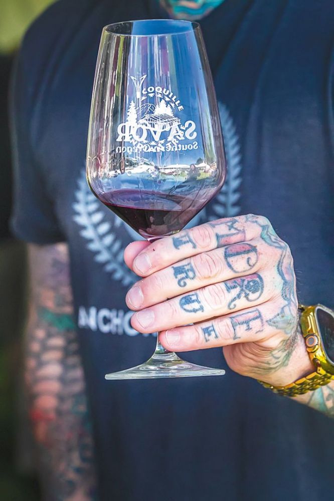 A person at Savor holding a glass of wine. ## Photo provided by Travel Medford