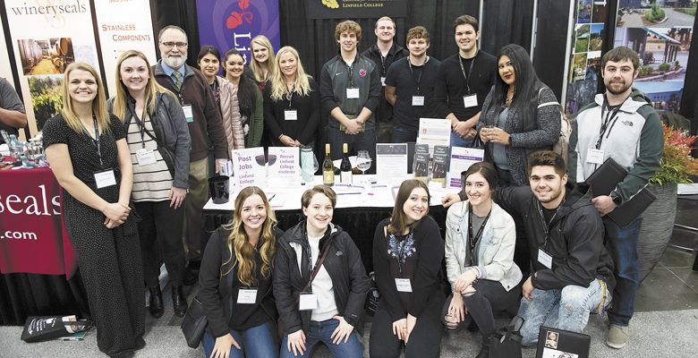 Greg Jones, the director of Linfield College’s Evenstad Center for Wine Education, joins students from the wine studies program on the tradeshow floor at the Oregon Convention Center in Portland. ##Photo by Carolyn Wells-Kramer