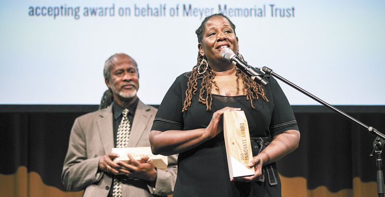 Michelle J. DePass accepts the Innovate Award on behalf of Meyer Memorial Trust. Standing behind her is Michael Alexander, recipient of the Inspire Award. ##Photo provided