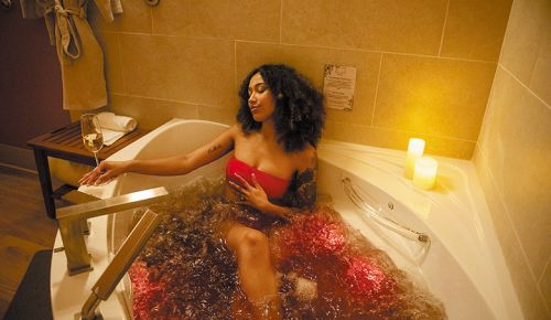 A woman relaxing in a tub filled with water and wine while sipping a glass of wine. ## Photo by Kara Cooper