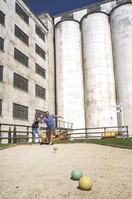 Visitors play bocce ball outside the Sunshine Mill in The Dalles; the towering silos formerly housed grains. Photo by Andrea Johnson.