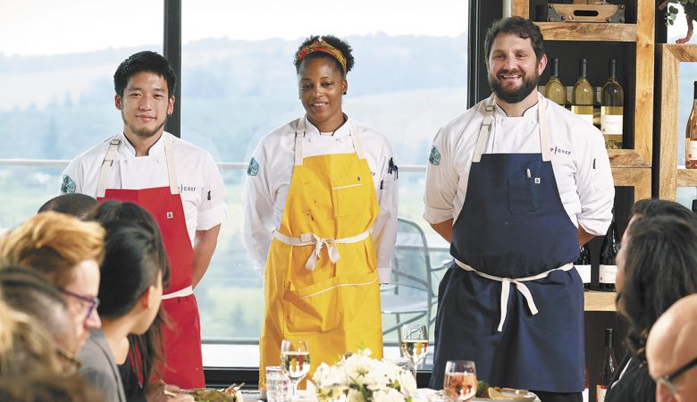 Finalists Shota Nakajima (from left), Dawn Burrell and Gabe Erales serve their dishes to an all-star judges’ panel alongside host Padma Lakshmi, head judge Tom Colicchio and judge Gail Simmons in Willamette Valley Vineyards’ tasting room. ##Photo by David Moir/Bravo