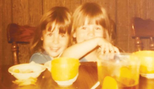 OWP editor Hilary Berg (right) with her twin sister, Jessica McHughes, at the  kitchen table of their youth.