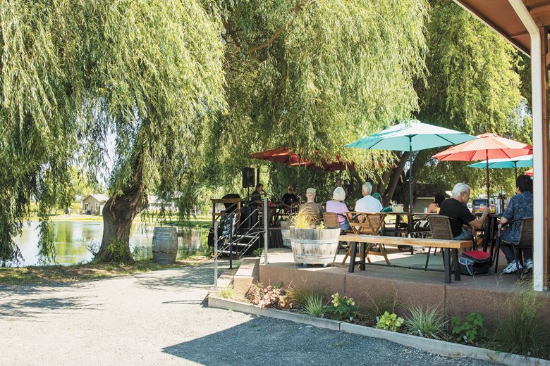 Colorful umbrellas offer shade to wine tasters at Dos Mariposas Vineyards & Lavender.