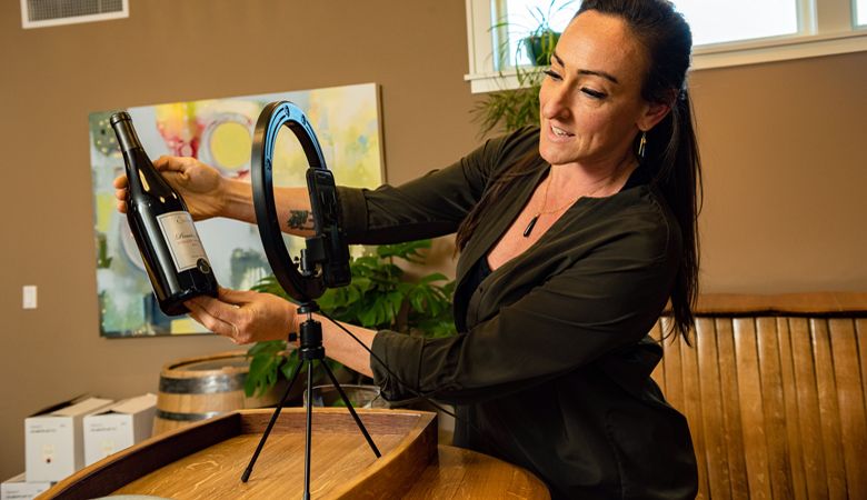 Seufert Winery team member Michelle Wasner gives viewers a close-up of the wine being discussed. ##Photo by  Kathryn Elsesser