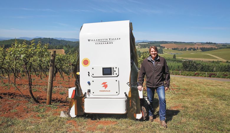 WVV founder Jim Bernau stands next to a cutting-edge robot that helps combat powdery mildew. ##Photo by Emily Krouse