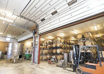 Massive, insulated
roll-up doors seal off the barrel cellar from the
main fermentation room at the new winery. Photo
by Marcus Larson.