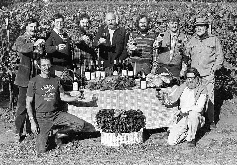 An iconic photo of the  founding  members of the Yamhill County Wineries Association, without their equally talented and supportive female spouses, raising their glasses in a toast for a publicity photograph for the first  Thanksgiving Weekend in Wine Country.  The women were asked by the photographer to step aside before taking the photo. Front row (kneeling, left to right): Joe Campbell, Elk Cove Winery; David Adelsheim, Adelsheim Vineyard. Back row (standing, left to right): Bill Blosser, Sokol Blosser Winery; Don Byard, Hidden Springs; Myron Redford, Amity Vineyards; Dick Erath, Erath Vineyards; Fred Arterberry, Arterberry Winery; Fred Benoit, Chateau Benoit; David Lett, The Eyrie Vineyards.
## Photo by Tom Ballard. Provided by Susan Sokol Blosser