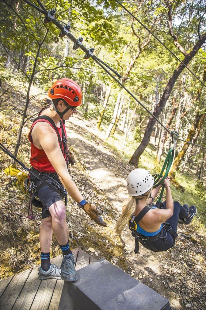 A guide helping someone off the zipline platform. ## Photo provided by Rogue Valley ZipLine Adventures