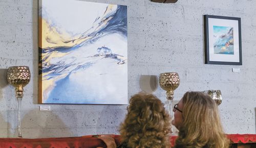 Guests at Hummingbird Estate looking at artwork. ##Photo by Kade Linville