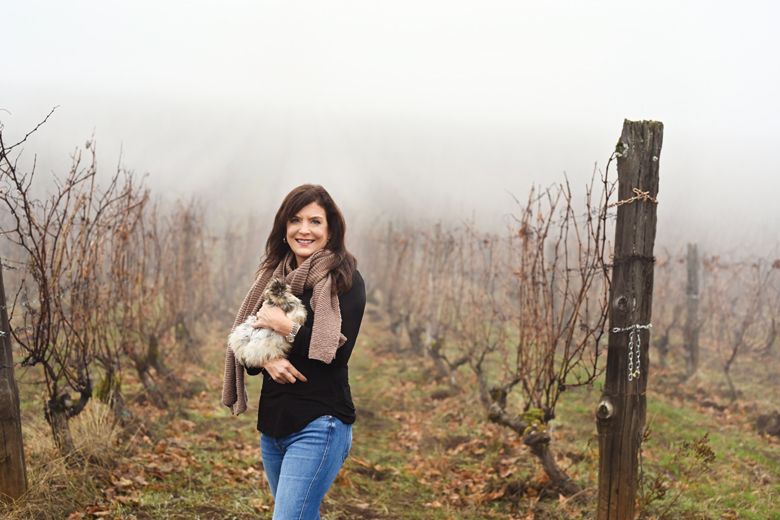 Brooks holding one of the many chickens who live at the Brooks Wine estate and vineyard. RiGhT: A member of the harvest crew at dawn with freshly picked wine grapes and a view of Mount Hood in the distance.