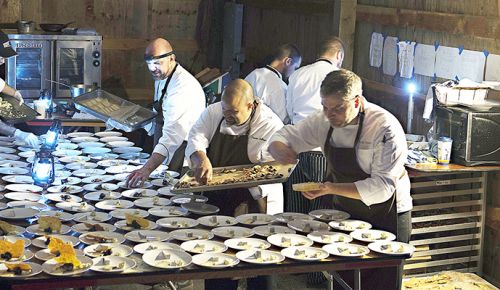 Hunt & Gather crew, led by co-owner/executive chef Andrew Biggs, assembles dishes in a barn at Bergström. Low-light conditions required staff to wear head lamps and light lanterns.