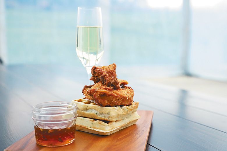 Chicken and waffles beside a serving of maple syrup and a glass of sparkling wine. ## Photo provided by Stoller Family Estate